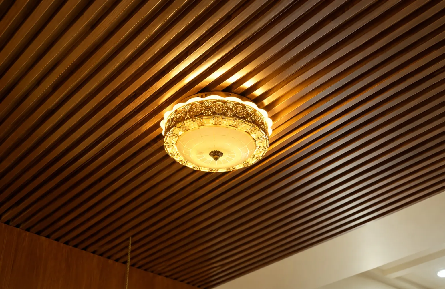 Timber-slat ceiling with an ornate round light fitting