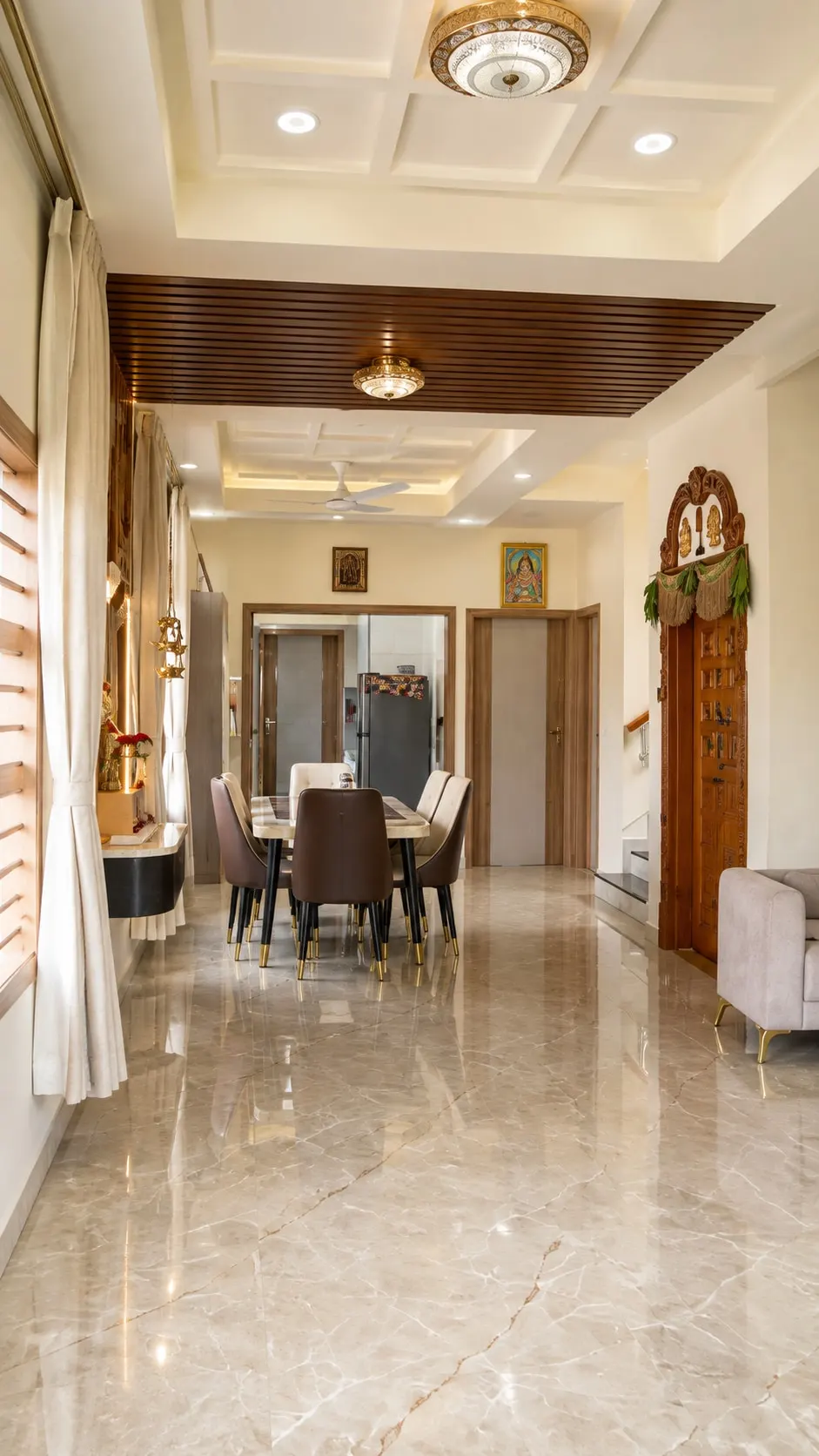 Hallway with a coffered ceiling and marble floor leading to the dining table