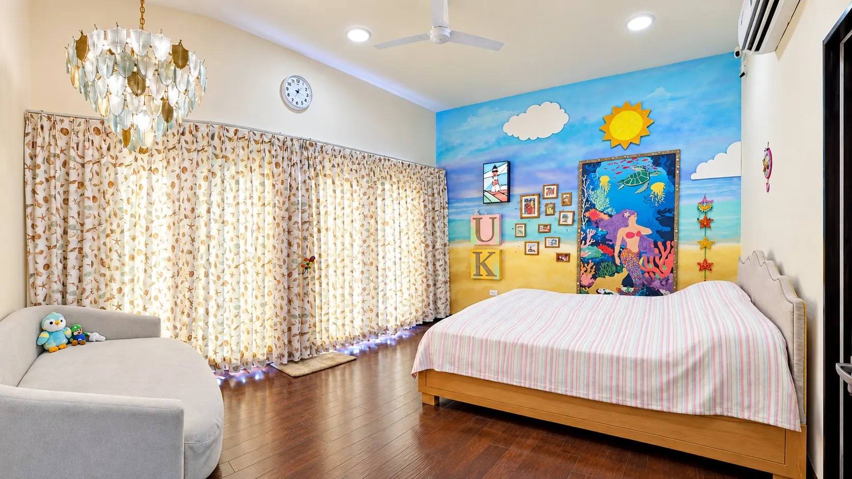 Child's bedroom with a seaside mural, a crystal chandelier, floral curtains and a single bed