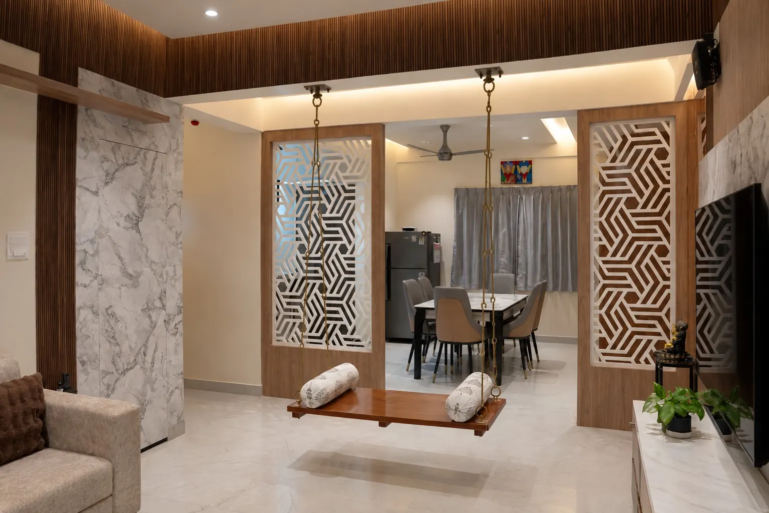 The swing framed by two laser-cut jaali screens, with the dining table visible beyond