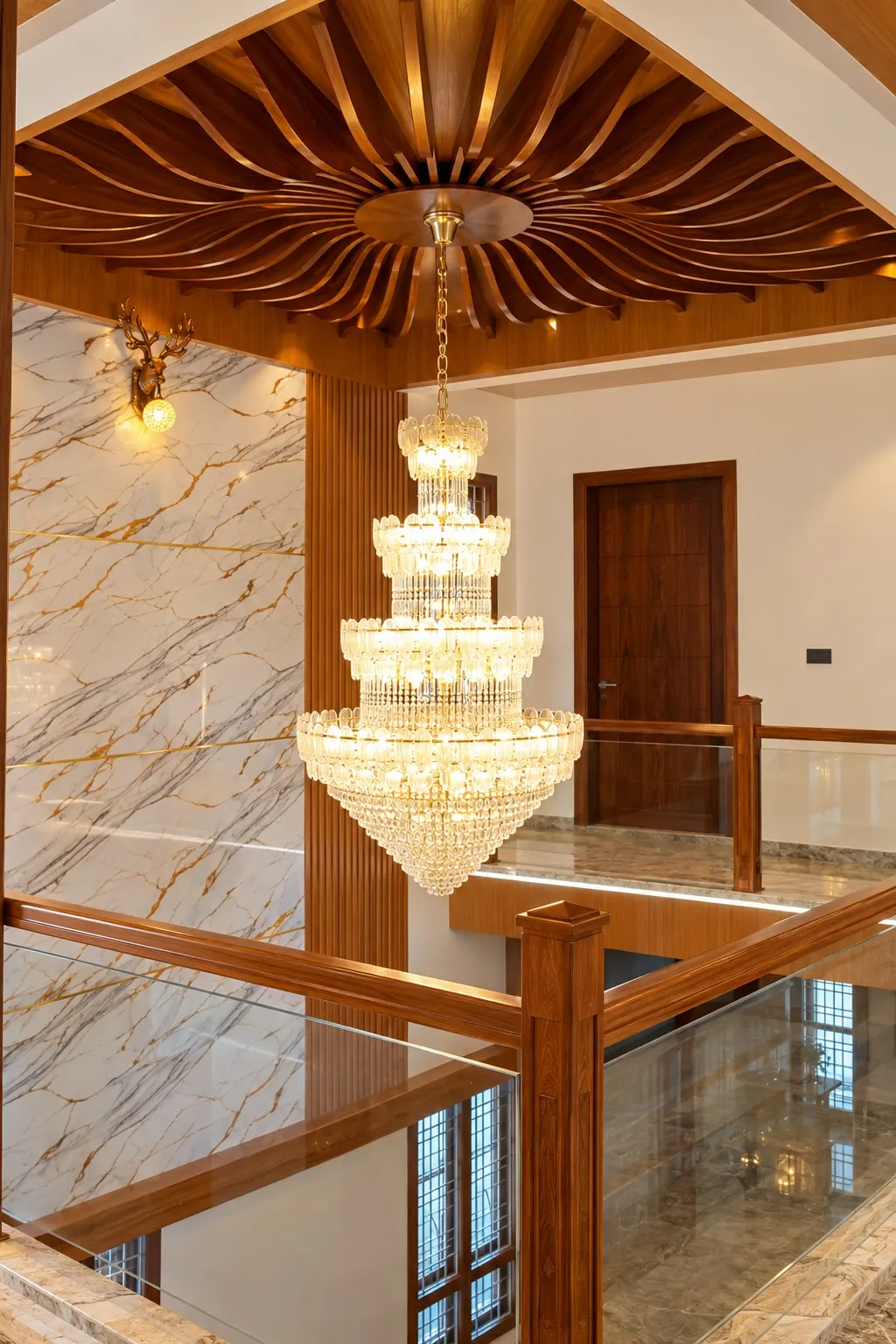 Upper landing with a tiered crystal chandelier under the radiating timber ceiling, a marble-finish wall and a timber-and-glass railing
